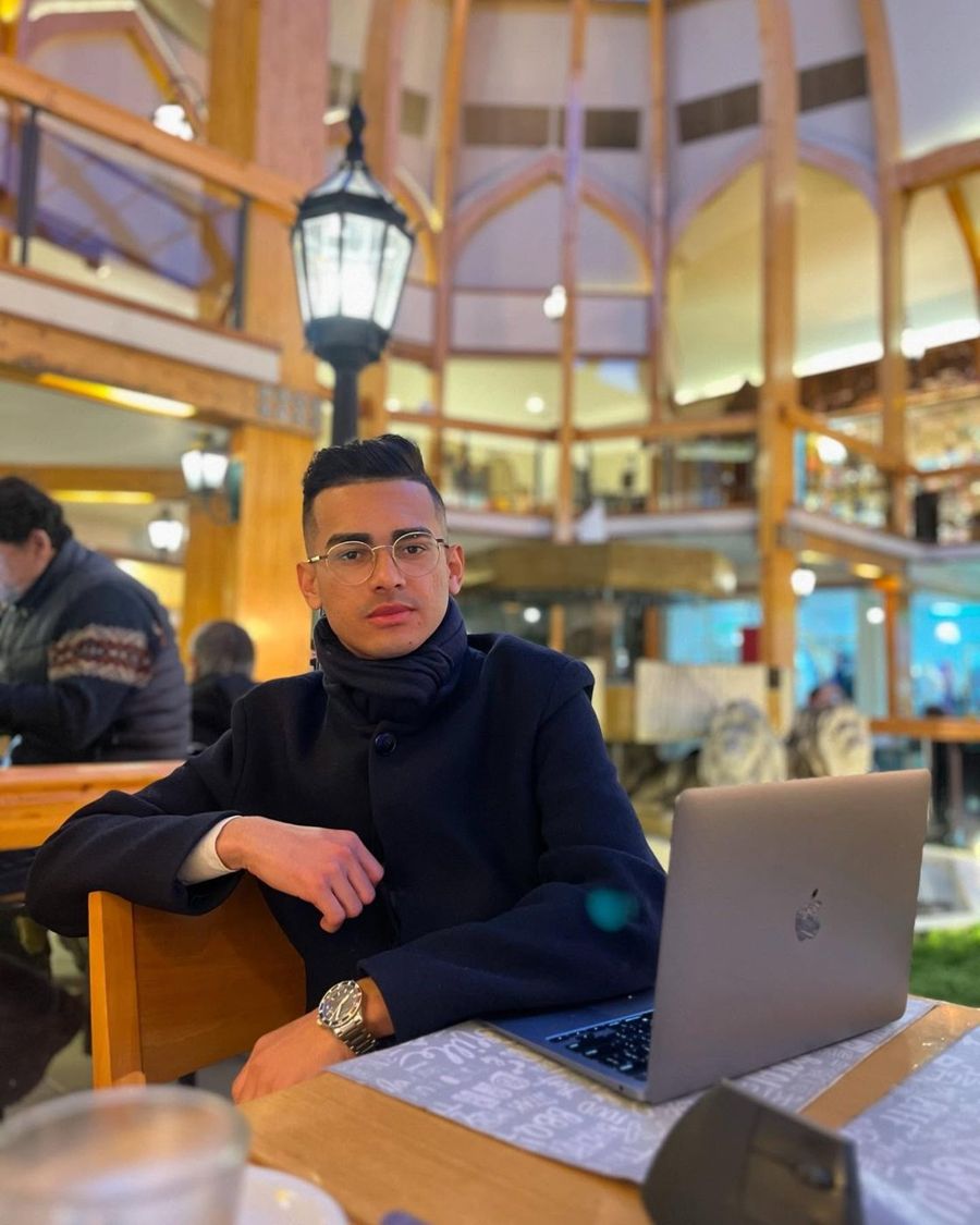 Retrato de Miguel Santos sentado em um café com o notebook